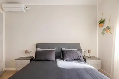 a bedroom with a large gray bed with two night stands at Roma Essence Vaticano e Comfort in Rome
