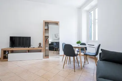 a living room with a tv and a table and chairs at Lilli's Home Garbatella in Rome