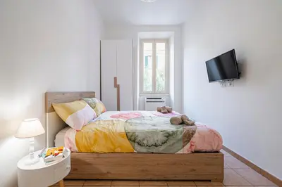 a bedroom with a bed and a flat screen tv at Lilli's Home Garbatella in Rome