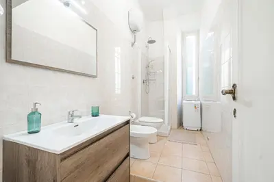 a white bathroom with a sink and a toilet at Lilli's Home Garbatella in Rome