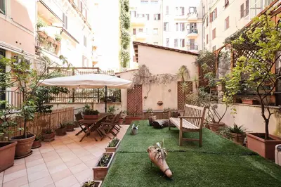 an outdoor patio with grass and an umbrella at Colosseum 3 rooms & 4 bathrooms with garden in Rome