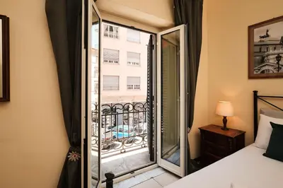 a bedroom with a bed and a glass door to a balcony at Colosseum 3 rooms & 4 bathrooms with garden in Rome