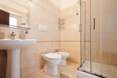 a bathroom with a toilet and a sink and a shower at Colosseum 3 rooms & 4 bathrooms with garden in Rome