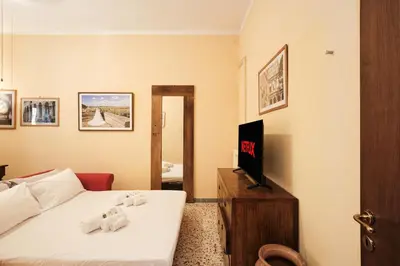 a bedroom with a bed and a tv and a mirror at Colosseum 3 rooms & 4 bathrooms with garden in Rome
