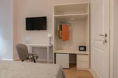 a bedroom with a desk and a bed with a monitor at Residenza Lucrezio in Rome