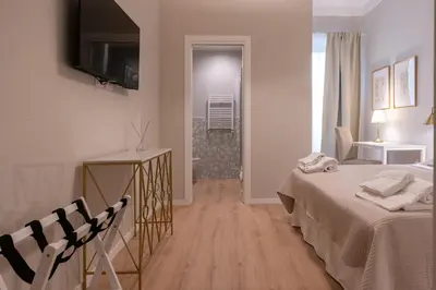 a hotel room with a bed and a television on the wall at Residenza Lucrezio in Rome