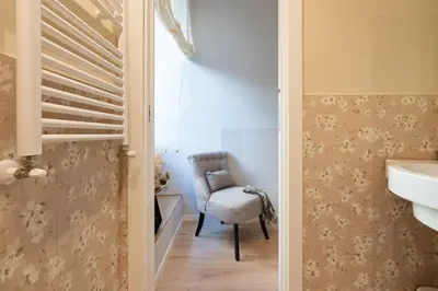a bathroom with a chair and a sink at Residenza Lucrezio in Rome