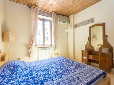 a bedroom with a blue bed and a mirror at Charming Luxury Trastevere Apartment in Rome