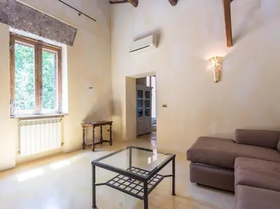 a living room with a couch and a glass table at Charming Luxury Trastevere Apartment in Rome