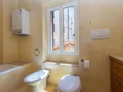 a bathroom with a white toilet and a window at Charming Luxury Trastevere Apartment in Rome