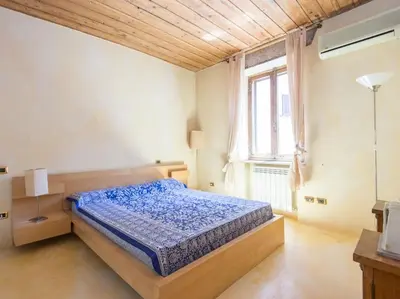 a bedroom with a bed and a large window at Charming Luxury Trastevere Apartment in Rome