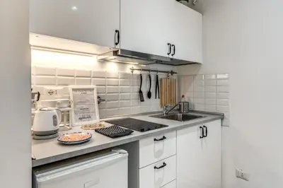 a kitchen with white cabinets and a sink at Loft in the Ghetto in Rome