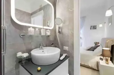 a bathroom with a sink and a mirror and a bed at Loft in the Ghetto in Rome
