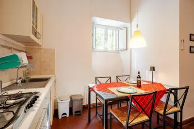 a small kitchen with a table with chairs and a tableablish at Loft Torlonia in Rome center town in Rome
