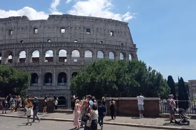 a group of people standing in front of the coliseum at Loft Torlonia in Rome center town in Rome