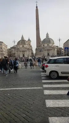 a street with a white car parked in front of a monument at Loft Torlonia in Rome center town in Rome