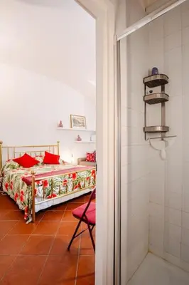 a bedroom with a bed and a red chair at Loft Torlonia in Rome center town in Rome