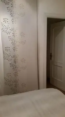 a bedroom with a white wall with a patterned wall at Little Villa Well connected in Rome