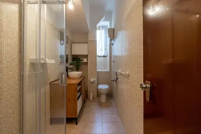 a bathroom with a toilet and a glass shower at Typical & Cozy Apartment - Testaccio - Trastevere in Rome