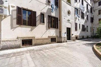 a building with windows and a cobblestone street at Typical & Cozy Apartment - Testaccio - Trastevere in Rome