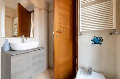 a bathroom with a sink and a toilet and a mirror at Maurice's Apt, hidden gem in Rome for food lovers in Rome