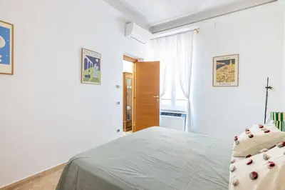 a white bedroom with a bed and a window at Maurice's Apt, hidden gem in Rome for food lovers in Rome