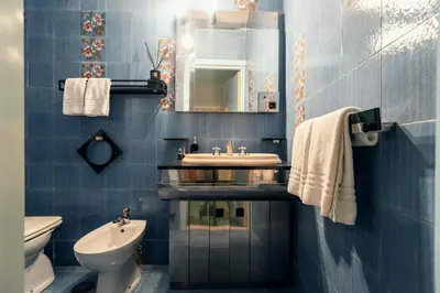 a blue bathroom with a sink and a toilet at Celeste Suite Reginella in Rome