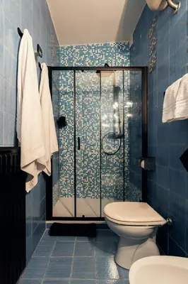 a blue bathroom with a shower and a toilet at Celeste Suite Reginella in Rome