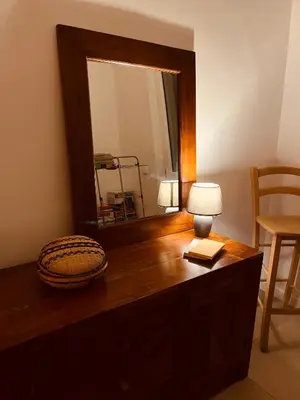 a wooden cabinet in a room with a chair at La Casa di Monteverde in Rome