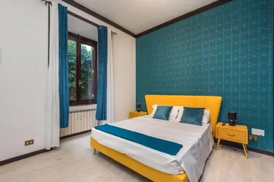 a bedroom with a yellow bed and a blue wall at Trastevere suites Luxury Garden Retreat in Rome
