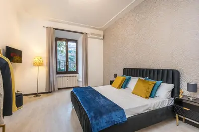 a bedroom with a bed with yellow and blue pillows at Trastevere suites Luxury Garden Retreat in Rome