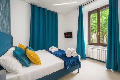 a bedroom with blue curtains and a bed with towels at Trastevere suites Luxury Garden Retreat in Rome