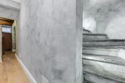 a staircase in a room with a concrete wall at Suite Experience Spanish Steps Apartment in Rome