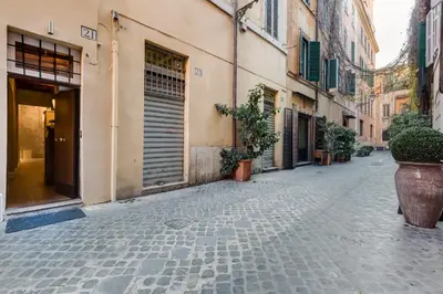 an empty street with potted plants and buildings at Suite Experience Spanish Steps Apartment in Rome