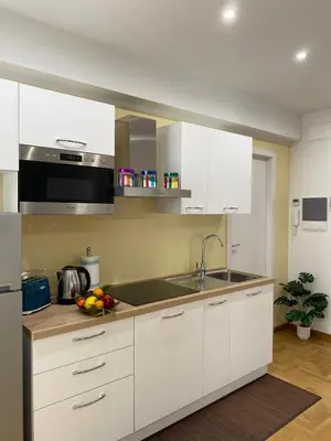 a kitchen with white cabinets and a sink at VMV Holiday houses in Rome