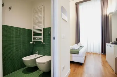 a green bathroom with a toilet and a sink at History Suite Essence in Rome