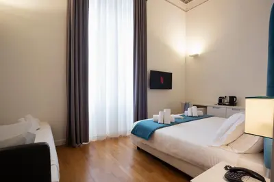 a hotel room with a bed and a desk at History Suite Essence in Rome