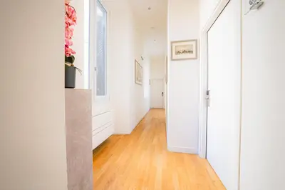 a hallway with white walls and a hard wood floor at History Suite Essence in Rome