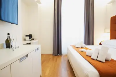 a white bedroom with a bed and a sink at History Suite Essence in Rome
