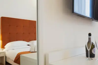 a bedroom with a bed and a bottle of wine at History Suite Essence in Rome