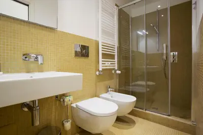 a bathroom with a toilet and a sink and a shower at History Suite Essence in Rome
