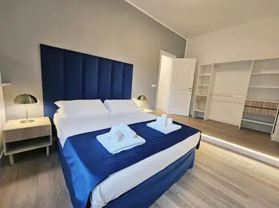 a bedroom with a large bed with a blue headboard at Angelico 70 - Amazing flat near the Vatican Museum in Rome