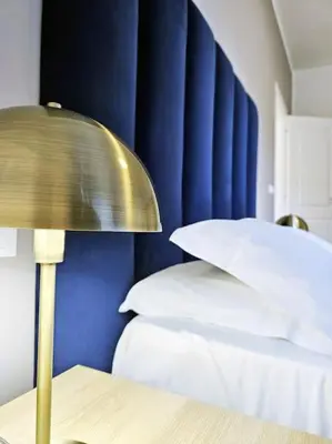 a lamp on a table next to a bed at Angelico 70 - Amazing flat near the Vatican Museum in Rome