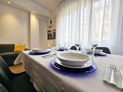 a table with plates and wine glasses on it at Angelico 70 - Amazing flat near the Vatican Museum in Rome