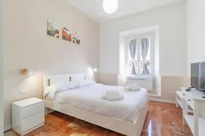 a white bedroom with a bed and a television at Residenza Cocchina Apt in Rome