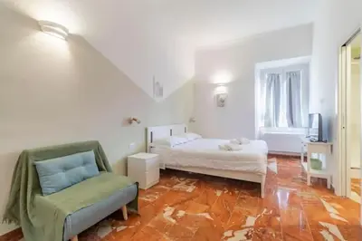 a bedroom with a bed and a chair in a room at Residenza Cocchina Apt in Rome