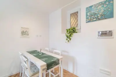 a white dining room with a table and chairs at Residenza Cocchina Apt in Rome