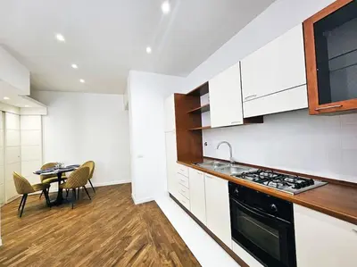 a kitchen with a stove and a table with chairs at Via Aubry 1- Vatican Museum in Rome