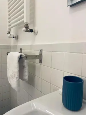 a bathroom with a sink and a toilet with towels at Sampietrino Vatican Apartment in Rome