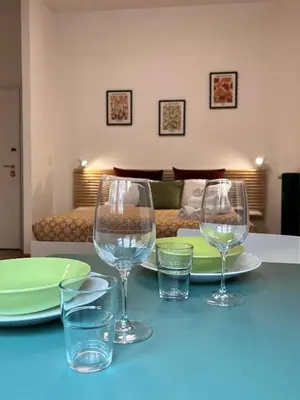 two wine glasses sitting on a table with a bed at Sampietrino Vatican Apartment in Rome